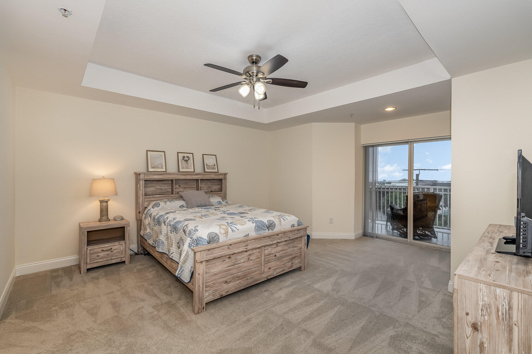 125 Pulsipher Avenue, Unit 402 Cocoa Beach, FL 32931 - Photo 16 of 34 a spacious bedroom with a bed and a chandelier