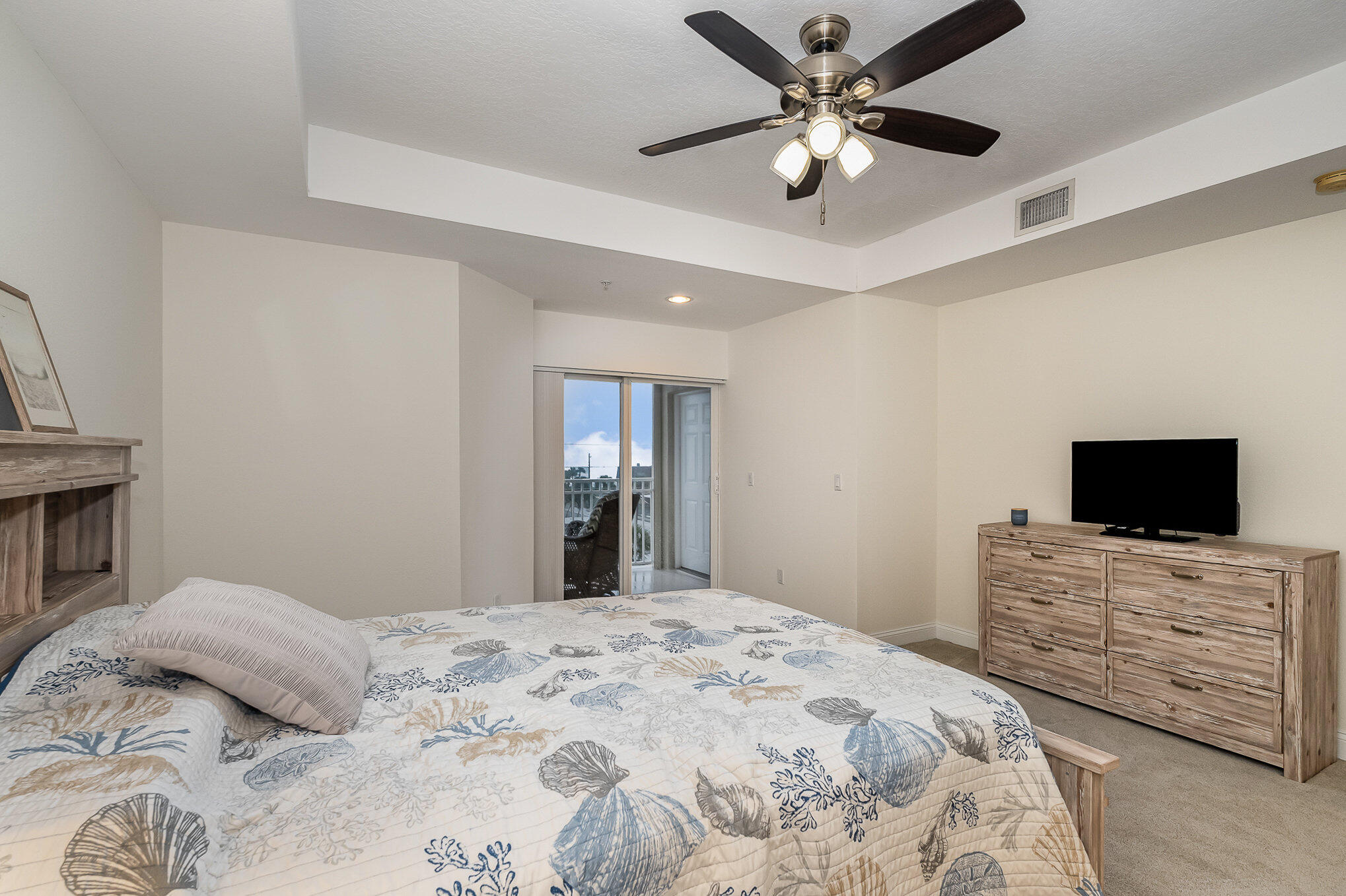 125 Pulsipher Avenue, Unit 402 Cocoa Beach, FL 32931 - Photo 17 of 34 a bedroom with a bed and a flat screen tv