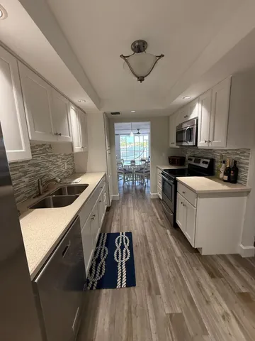 a kitchen with granite countertop a sink a stove and cabinets