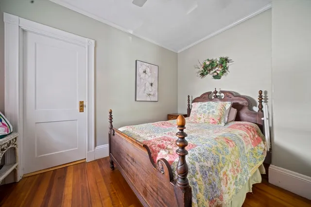 a bedroom with a bed and a wooden floor