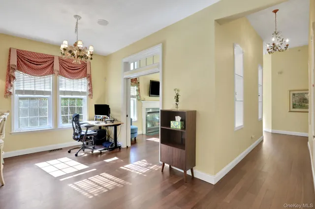 a view of a dining room with furniture a chandelier and wooden floor
