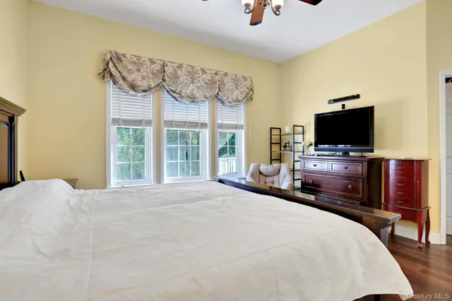 a bedroom with a bed tv and a window