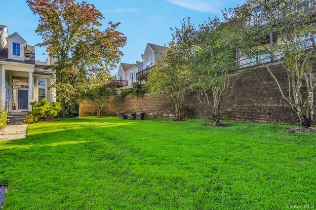 a view of a yard in front of a house with a large tree