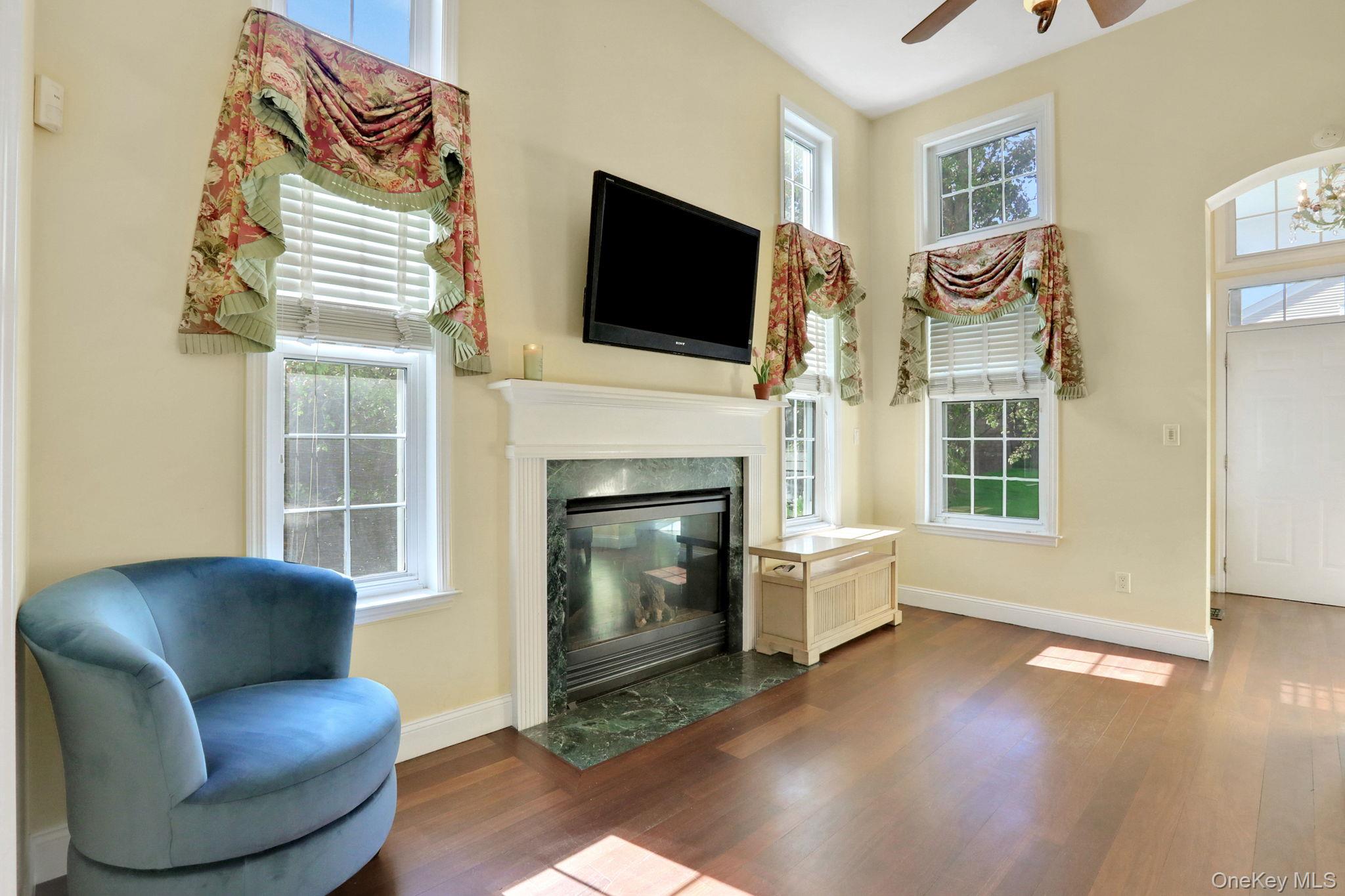 26 Reunion Road Rye Brook, NY 10573 - Photo 5 of 48 a living room with furniture a flat screen tv and a fireplace