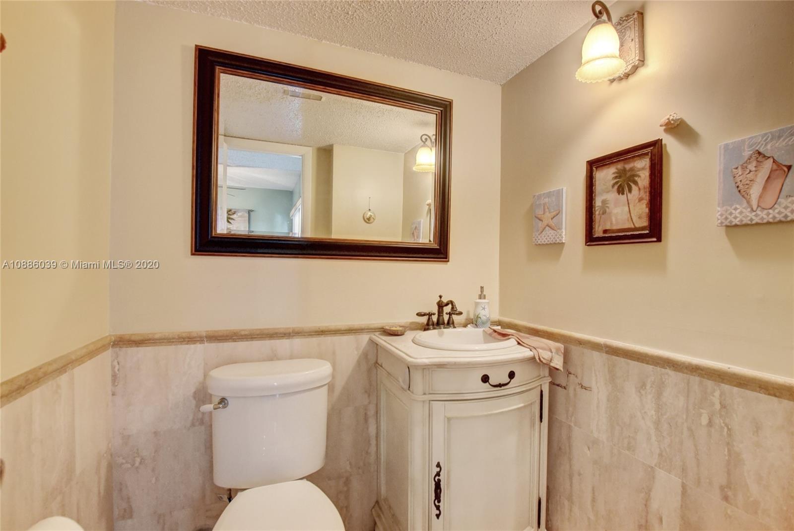 22415 Southwest 61st Way, Unit 107 Boca Raton, FL 33428 - Photo 23 of 48 a white toilet sitting next to a bathroom sink