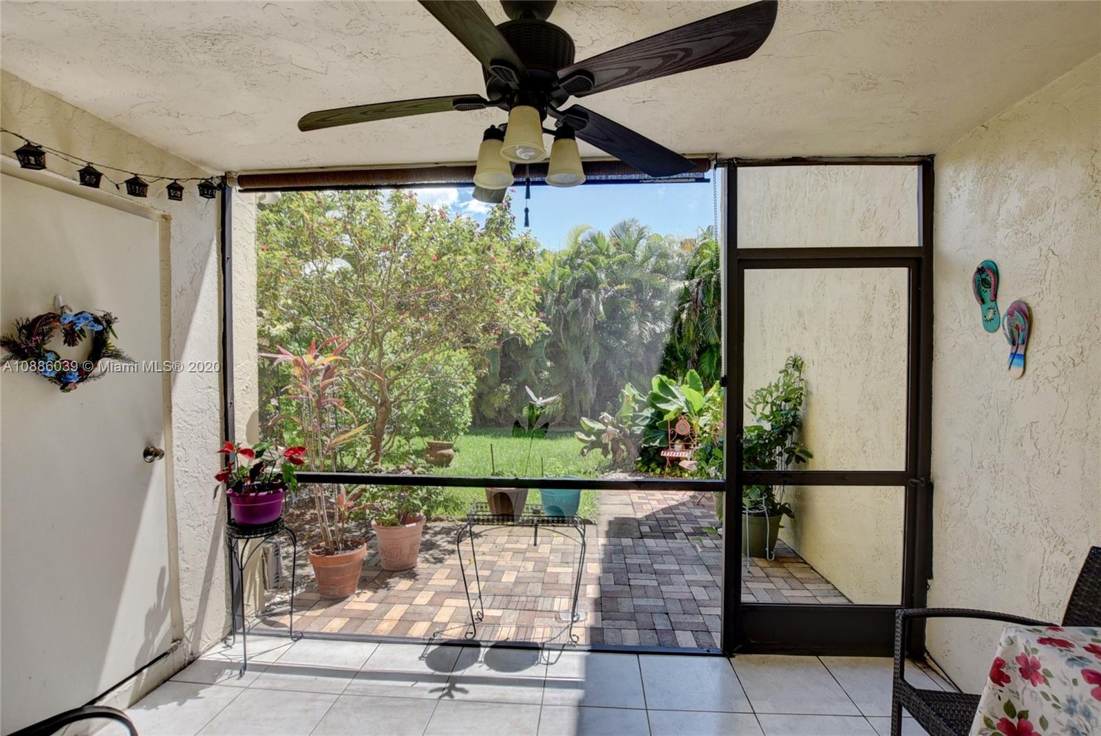 22415 Southwest 61st Way, Unit 107 Boca Raton, FL 33428 - Photo 8 of 48 a view of a porch with a floor to ceiling window and a table