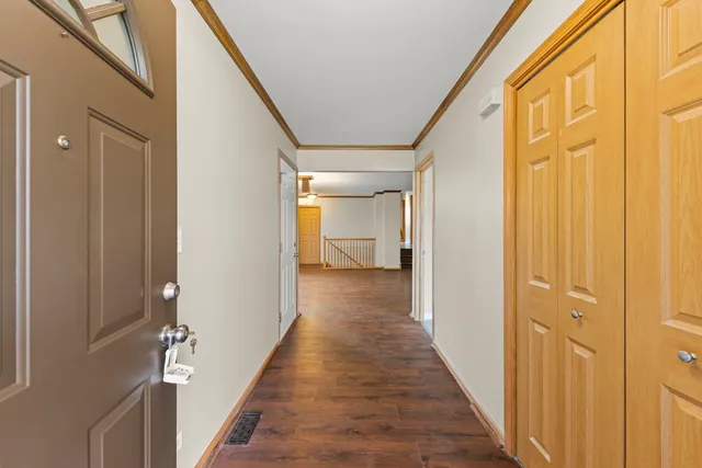 a view of a hallway with wooden floor and staircase