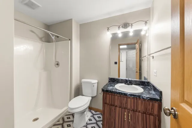 a bathroom with a sink toilet a mirror and shower