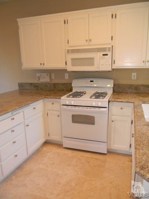 11525 Treeview Court Moorpark, CA 93021 - Photo 6 of 17 a kitchen with granite countertop white cabinets and white appliances