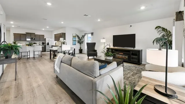 a living room with furniture a flat screen tv and a floor to ceiling window