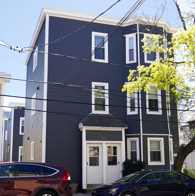 144 Spring Street Cambridge, MA 02141 - Photo 1 of 12 a front view of a house with a yard
