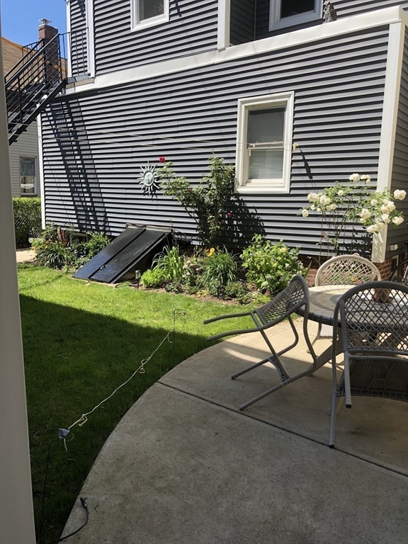 144 Spring Street Cambridge, MA 02141 - Photo 11 of 12 a view of backyard with a chair and potted plants