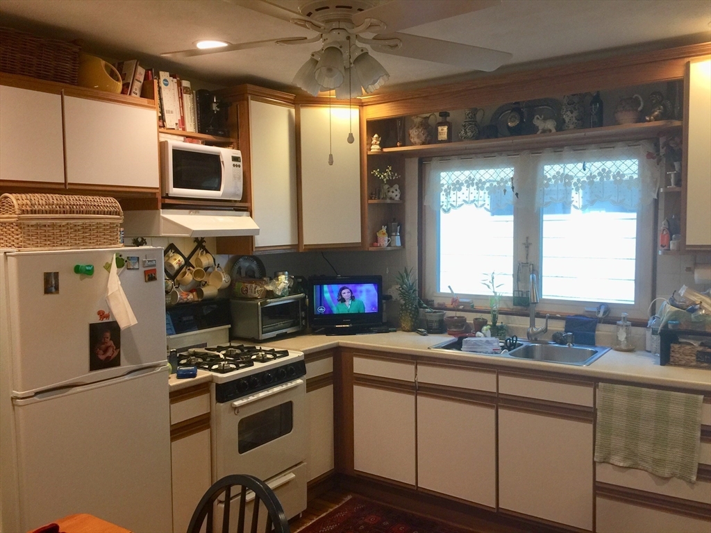 144 Spring Street Cambridge, MA 02141 - Photo 3 of 12 a kitchen with stainless steel appliances a sink a stove and a refrigerator