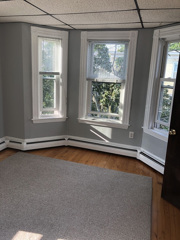 144 Spring Street Cambridge, MA 02141 - Photo 9 of 12 en empty room with a fireplace and large windows