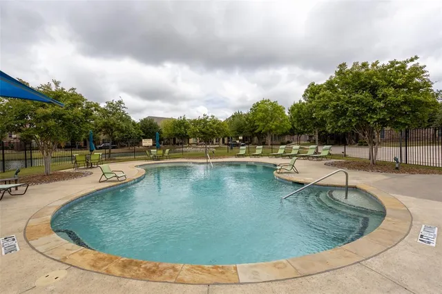 a view of a swimming pool with outdoor seating and plants