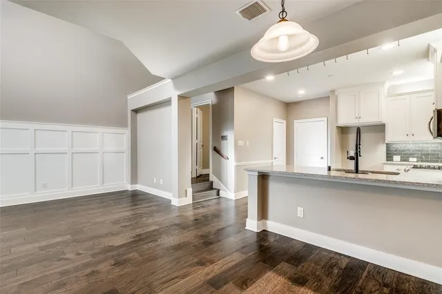 a view of a kitchen with wooden floor and a refrigerator