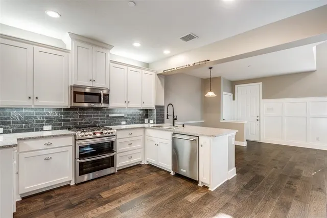 a kitchen with stainless steel appliances granite countertop a stove and a sink