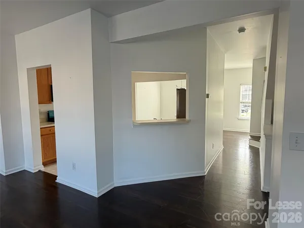 a view of a hallway with wooden floor and a cabinet