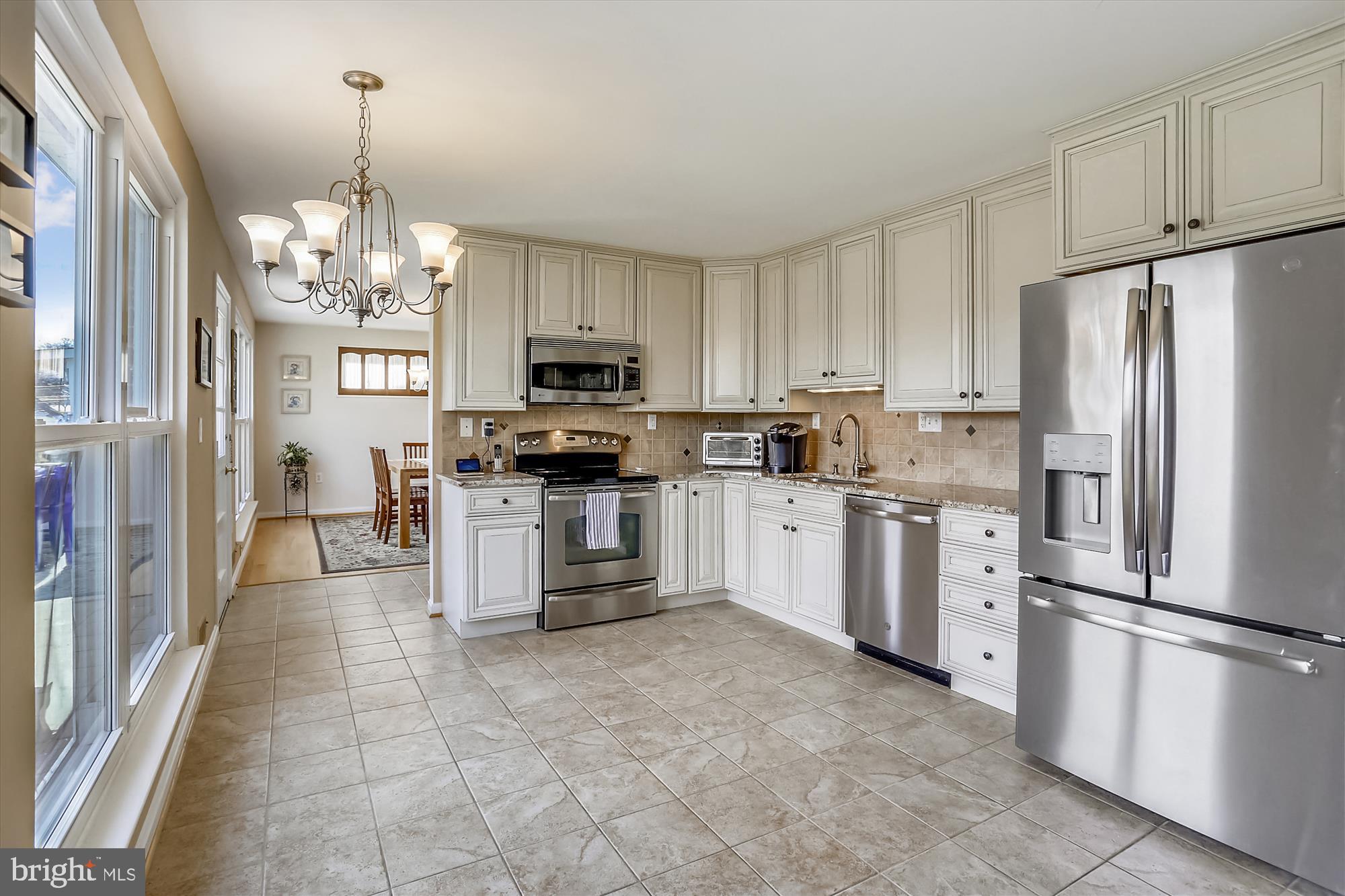 13005 Carney Street Silver Spring, MD 20906 - Photo 2 of 30 a kitchen with white cabinets stainless steel appliances and a window