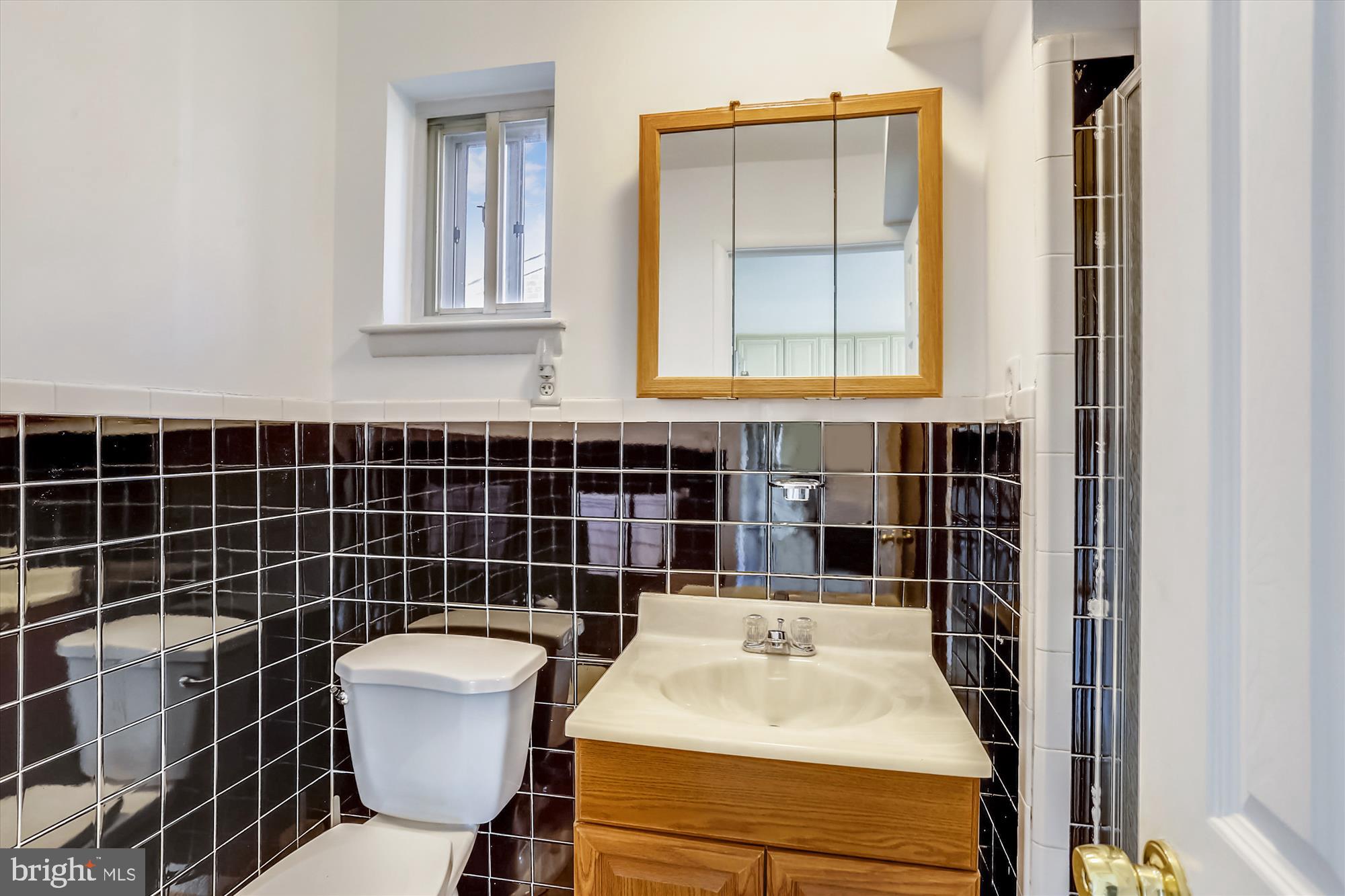 13005 Carney Street Silver Spring, MD 20906 - Photo 25 of 30 a bathroom with a toilet a sink and mirror