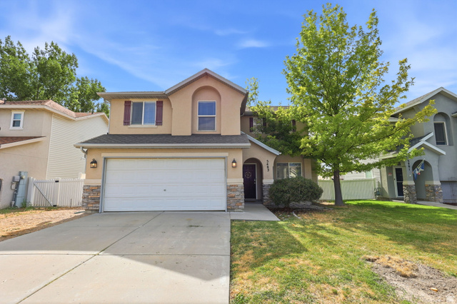 5485 Heather Way Tooele, UT 84074 - Photo 10 of 41 Two-story residence featuring a stucco exterior with stone accents, a two-car garage, and a concrete driveway