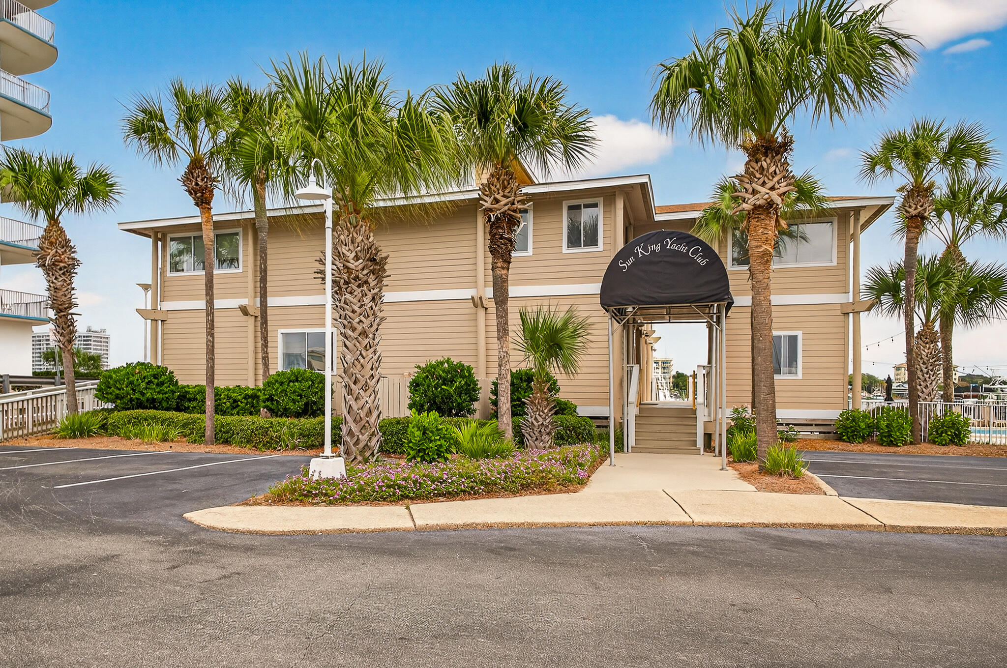 195 Durango Road, Unit 2D Destin, FL 32541 - Photo 12 of 62 a front view of a house with a yard and palm trees