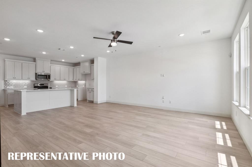 1027 Splitrock Drive Allen, TX 75013 - Photo 18 of 18 a view of kitchen with kitchen island stainless steel appliances wooden floor cabinets and a window