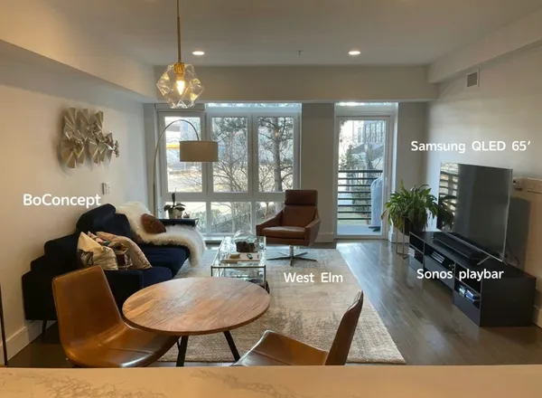 a living room with furniture a chandelier and a flat screen tv