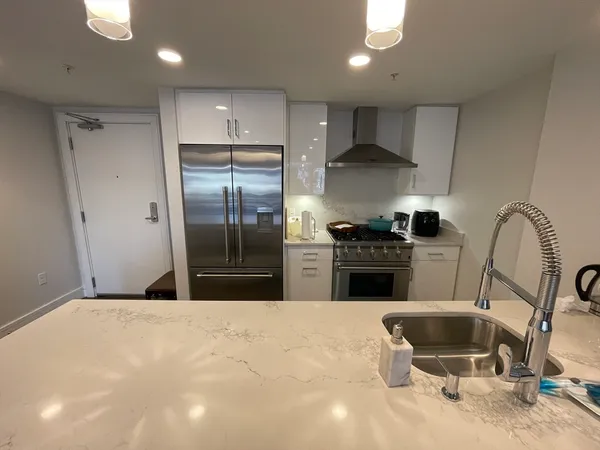 a kitchen with kitchen island a stove a refrigerator and a sink