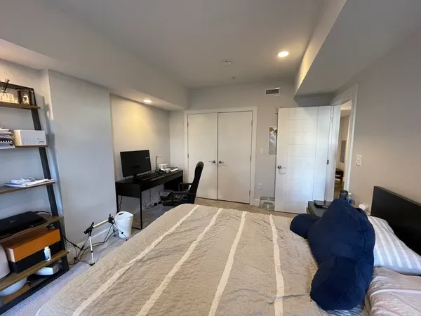 a bed room with a bed and a computer on a desk