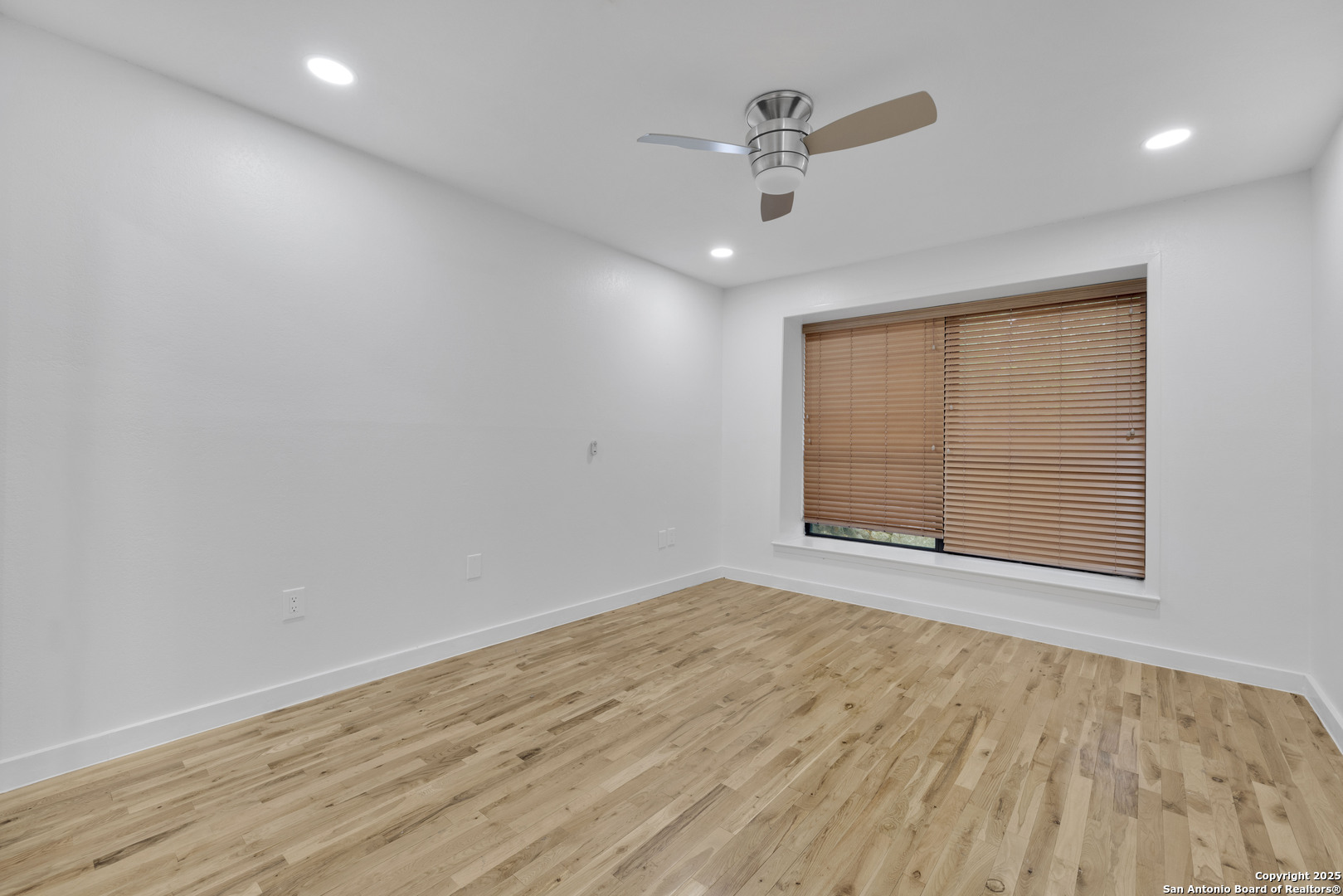 11361 Moonsail Helotes, TX 78023 - Photo 18 of 27 an empty room with wooden floor chandelier fan and windows