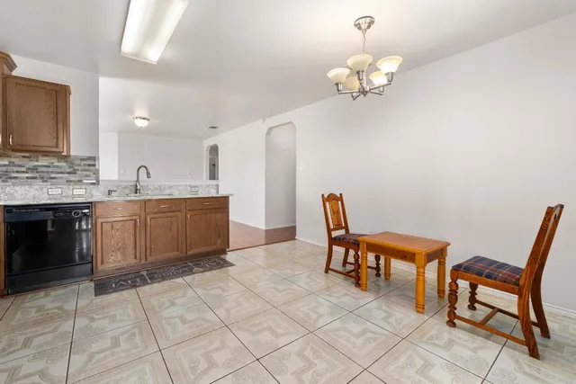 a living room with a table chairs and a kitchen view