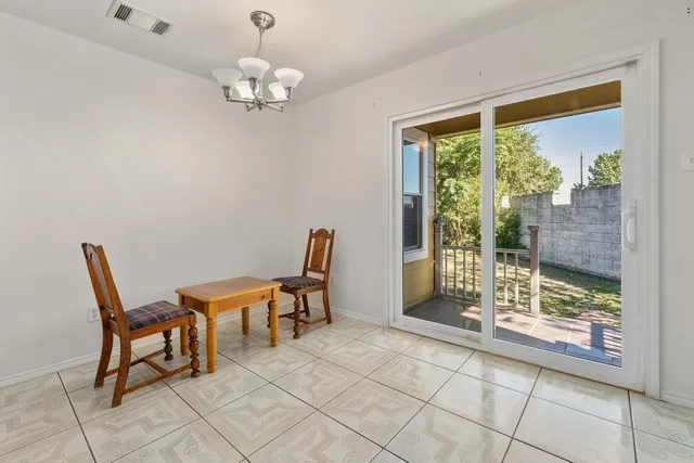 a dining room with chandelier and glass door