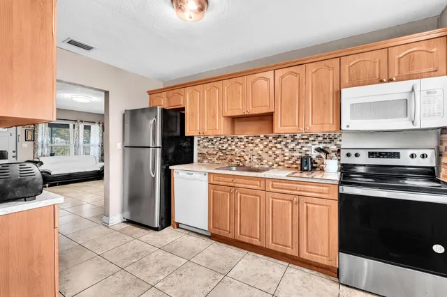 a kitchen with a refrigerator sink and stove