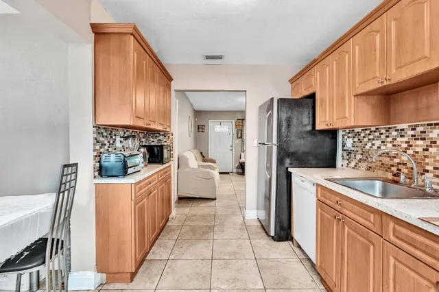a kitchen with stainless steel appliances granite countertop a sink a stove and a refrigerator