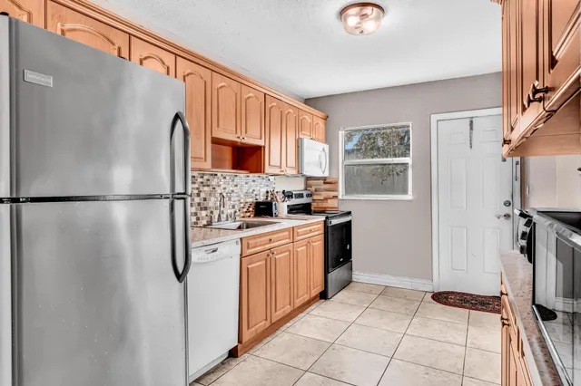 a kitchen with stainless steel appliances a refrigerator sink and cabinets