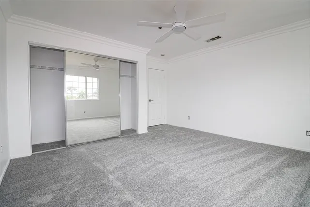 an empty room with fan and windows