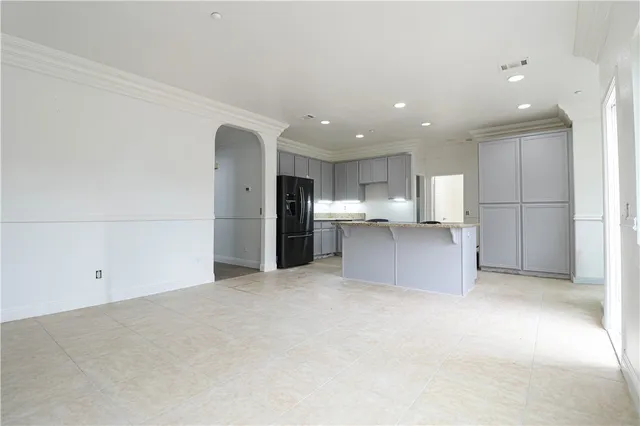 a view of kitchen with refrigerator and white cabinets