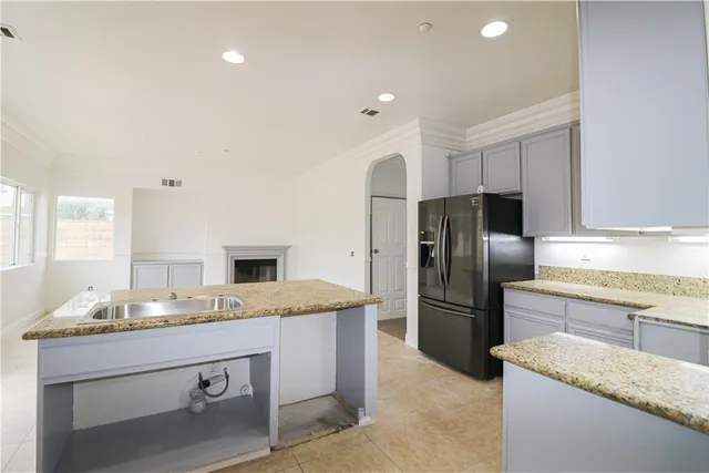 a kitchen with granite countertop a refrigerator and a sink