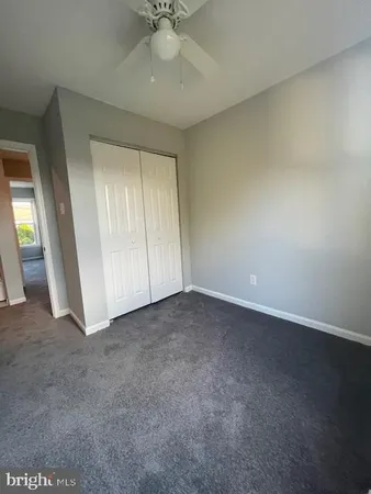 an empty room with a ceiling fan and window