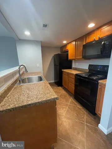 a kitchen with stainless steel appliances granite countertop a sink a stove and a microwave