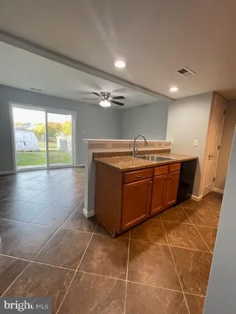 a room with kitchen island a sink a stove and a large window