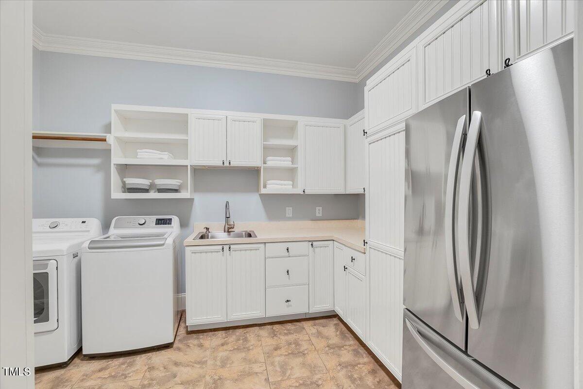 2909 Spaldwick Court Raleigh, NC 27613 - Photo 45 of 86 a kitchen with stainless steel appliances a refrigerator a sink and white cabinets