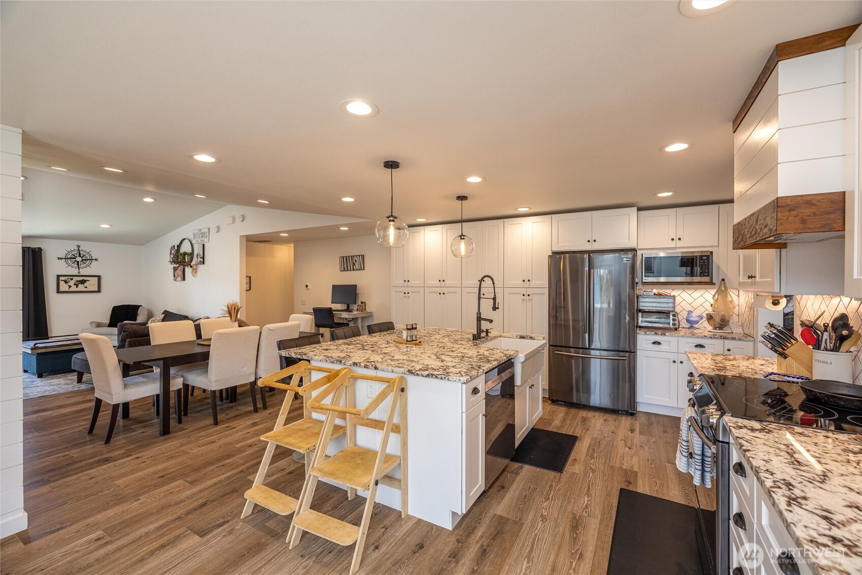 8679 Depot Road Lynden, WA 98264 - Photo 9 of 40 a kitchen with a refrigerator a stove and a dining table with wooden floor
