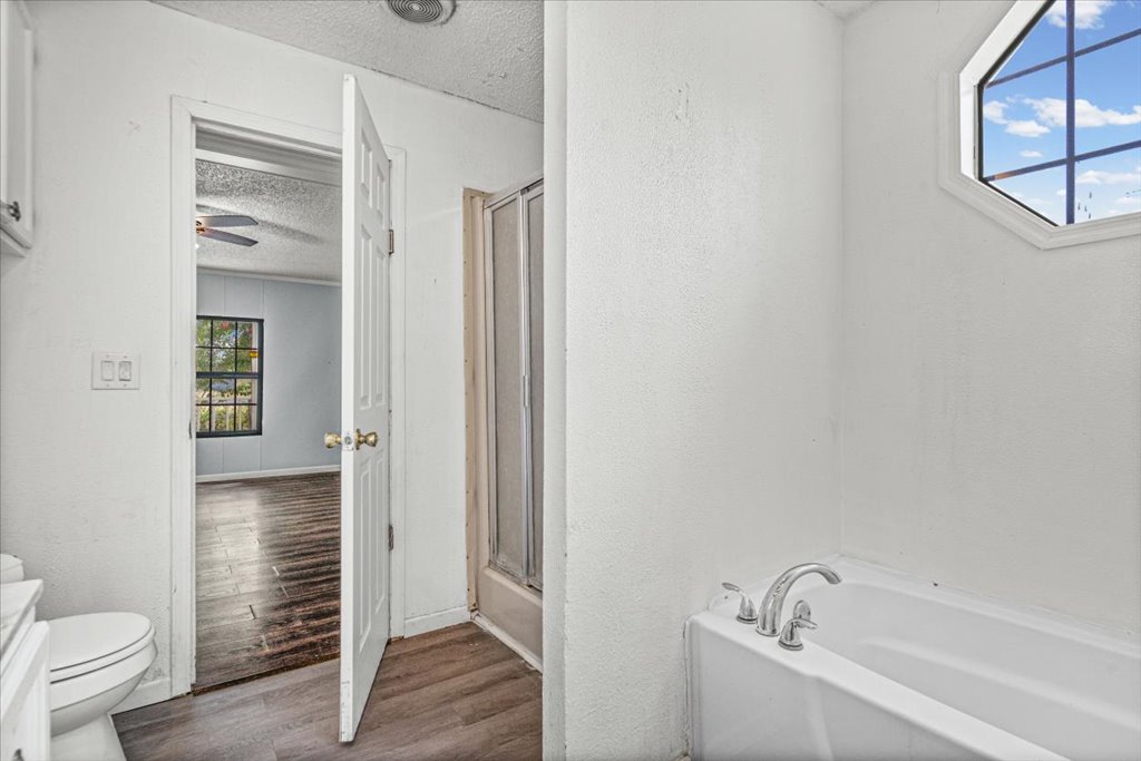 13501 Nutty Brown Road, Unit B Austin, TX 78737 - Photo 11 of 29 A well-lit bathroom features a built-in tub and an octagonal window with natural light.