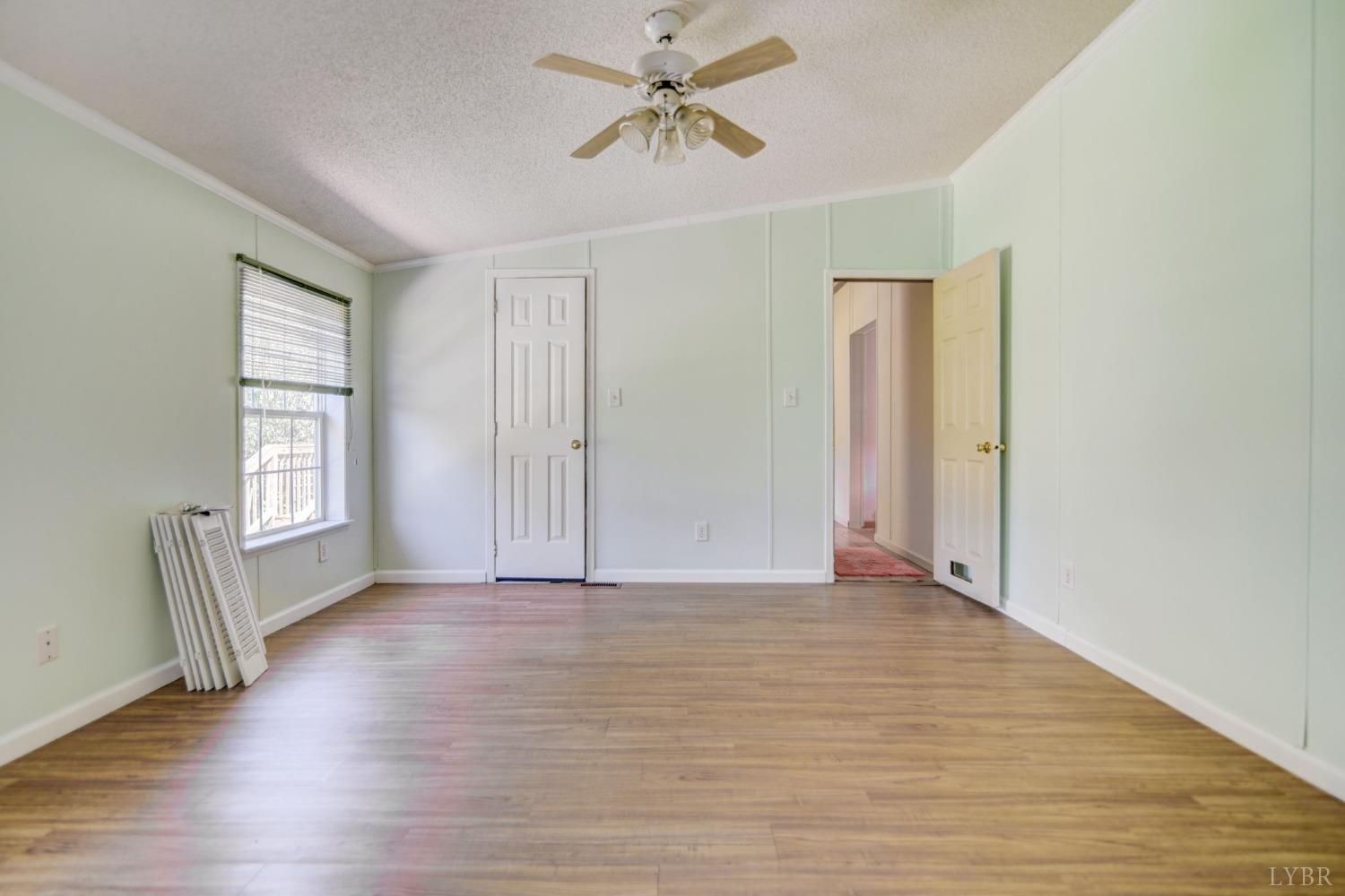 349 Theta Mill Road Gladys, VA 24554 - Photo 19 of 48 an empty room with wooden floor chandelier fan and windows