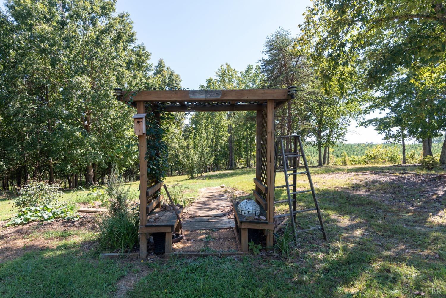 349 Theta Mill Road Gladys, VA 24554 - Photo 35 of 48 a view of a wooden deck with a bench and lawn chairs