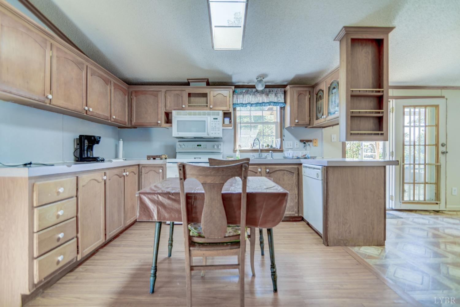 349 Theta Mill Road Gladys, VA 24554 - Photo 7 of 48 a kitchen with stainless steel appliances granite countertop a table chairs sink and cabinets