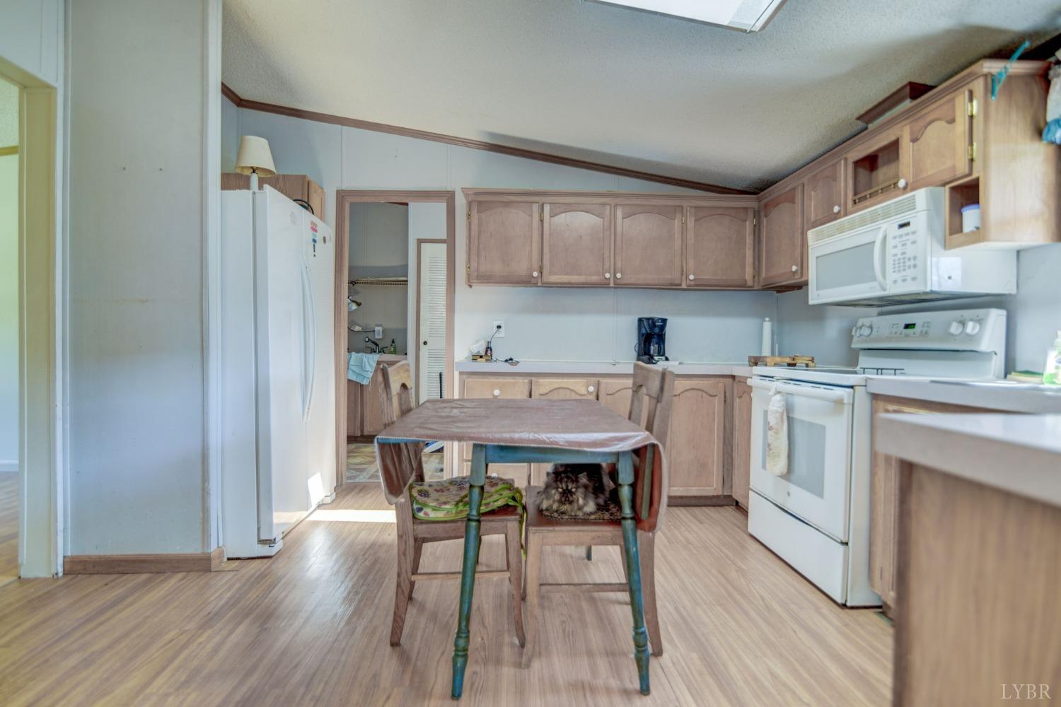 349 Theta Mill Road Gladys, VA 24554 - Photo 10 of 48 a kitchen with a table chairs refrigerator and cabinets