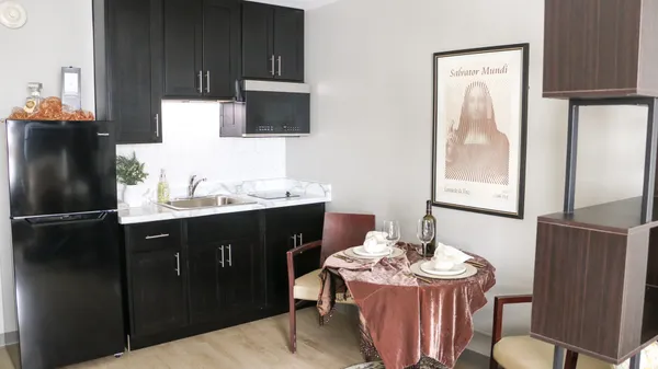 a kitchen with a table chairs refrigerator and microwave